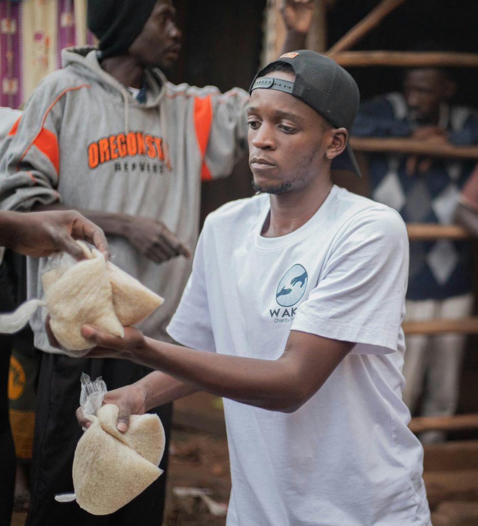 Young volunteers distribute food packs to community members during a charity event.